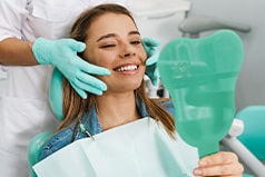 Woman smiling while looking at reflection in mirror